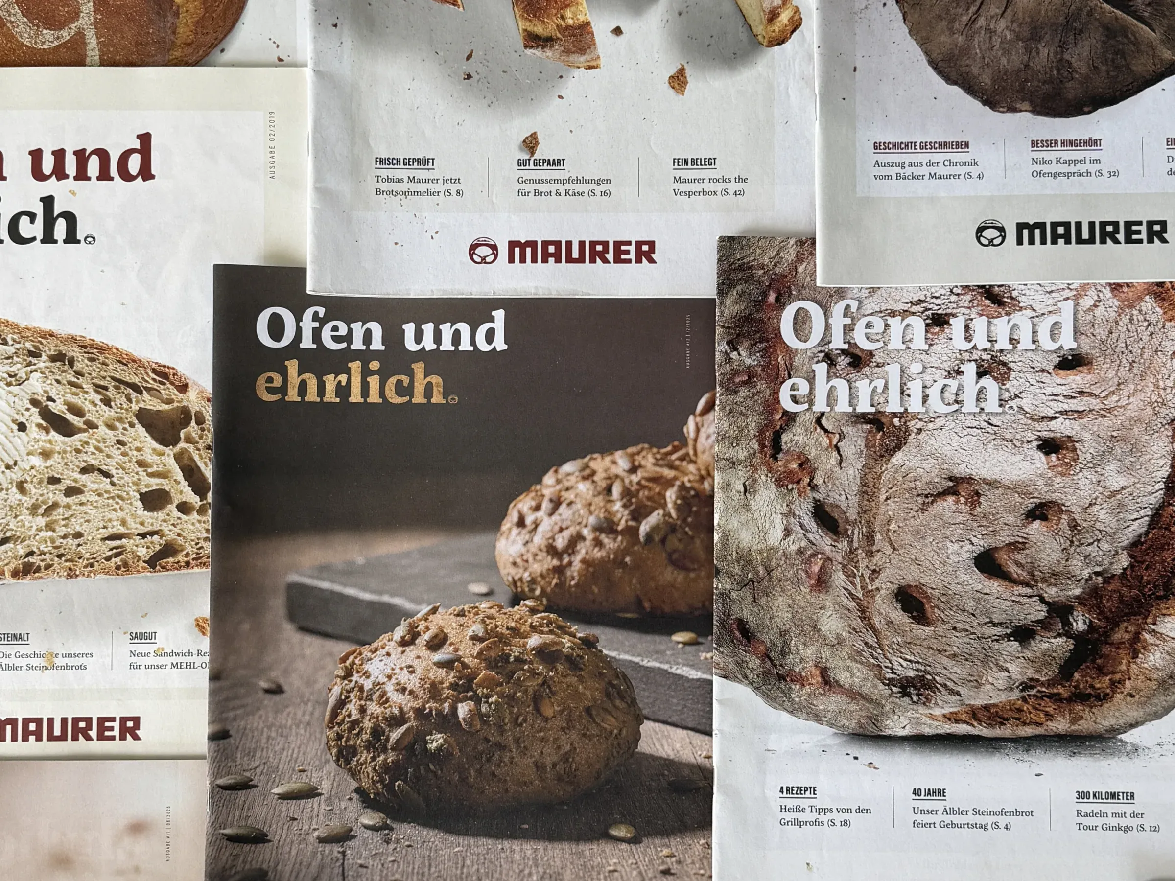 Fünf Titelseiten des Maurer-Magazins liegen überlappend nebeneinander, mit Brot und Brötchen auf den Titeln und zweimal dem Satz „Ofen und ehrlich.“