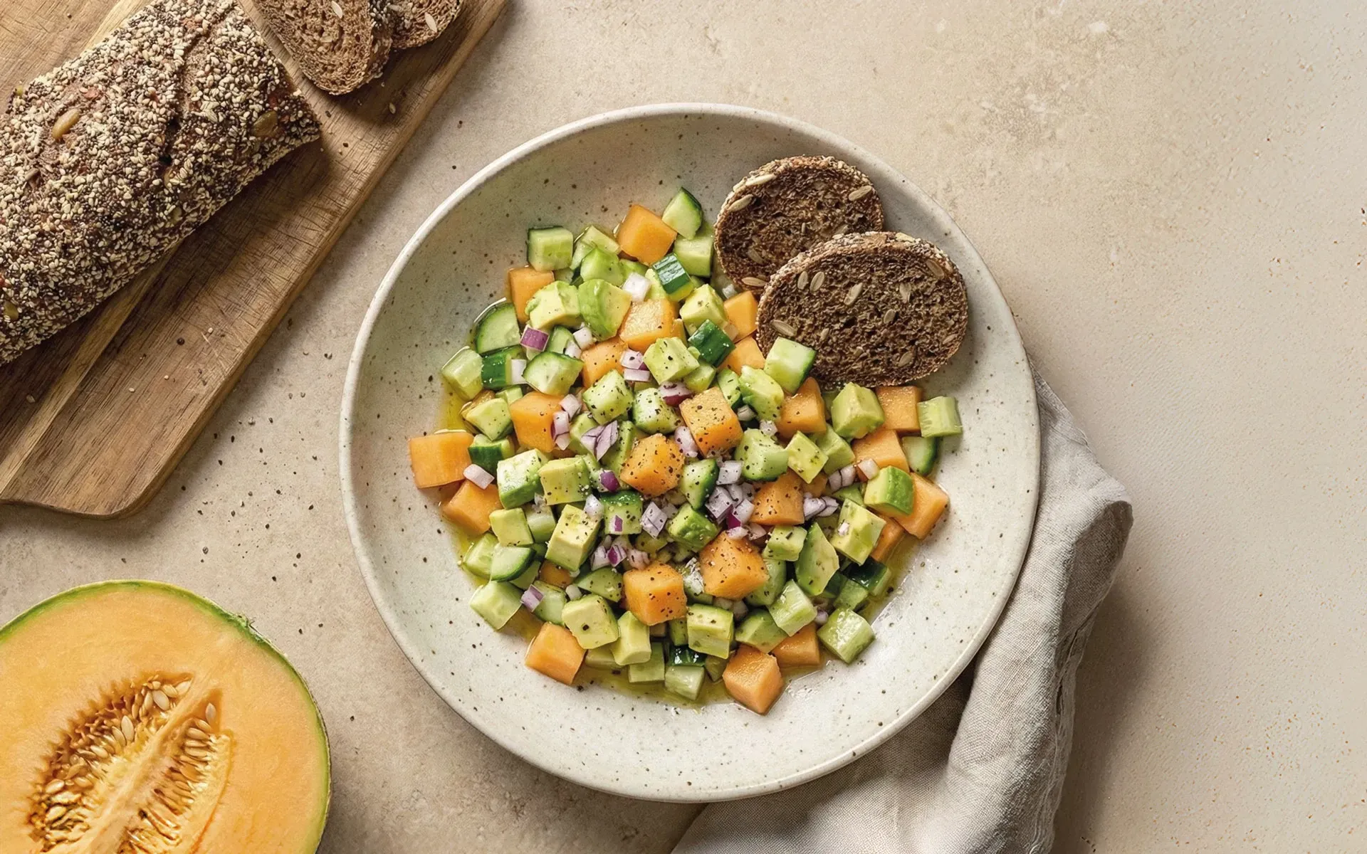 Power-Salat mit Vespergurke, Cantaloupe und Avocado, angerichtet