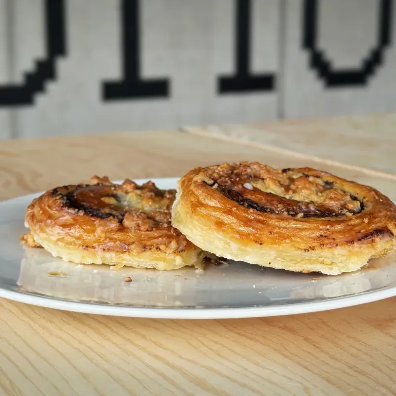 Zwei Nussschnecken mit glänzender Glasur auf einem weißen Teller