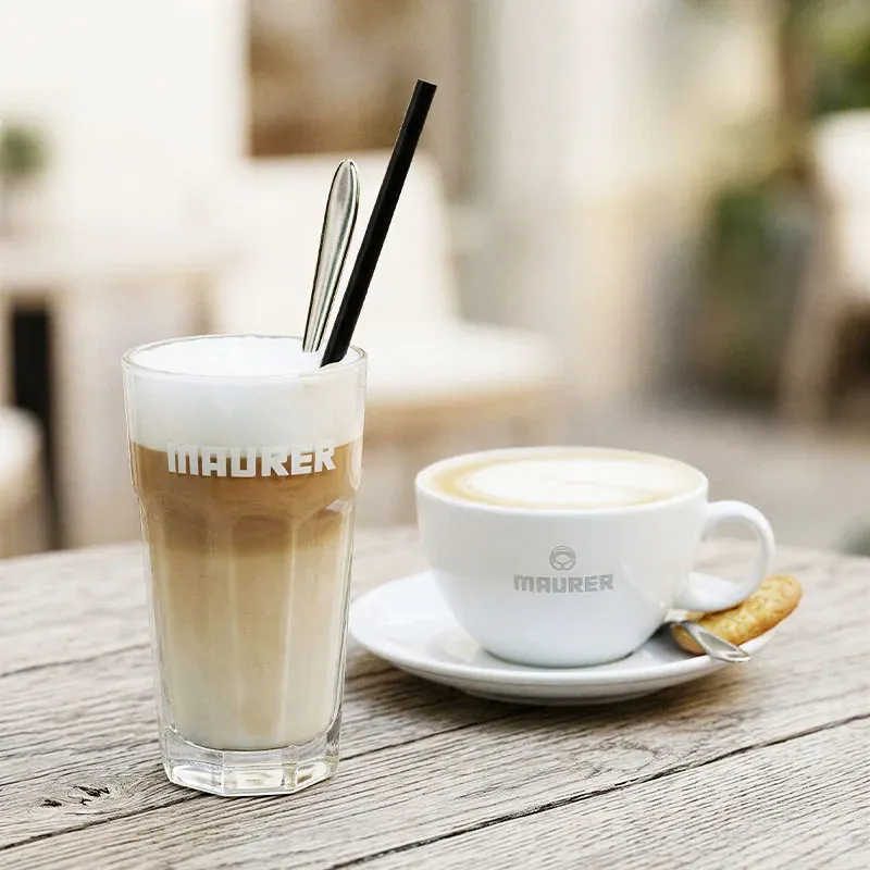 Latte Macchiato im Maurer-Glas und Cappuccino in der Maurer-Tasse auf Holztisch